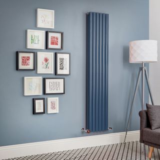 Blue vertical radiator on blue wall in living room