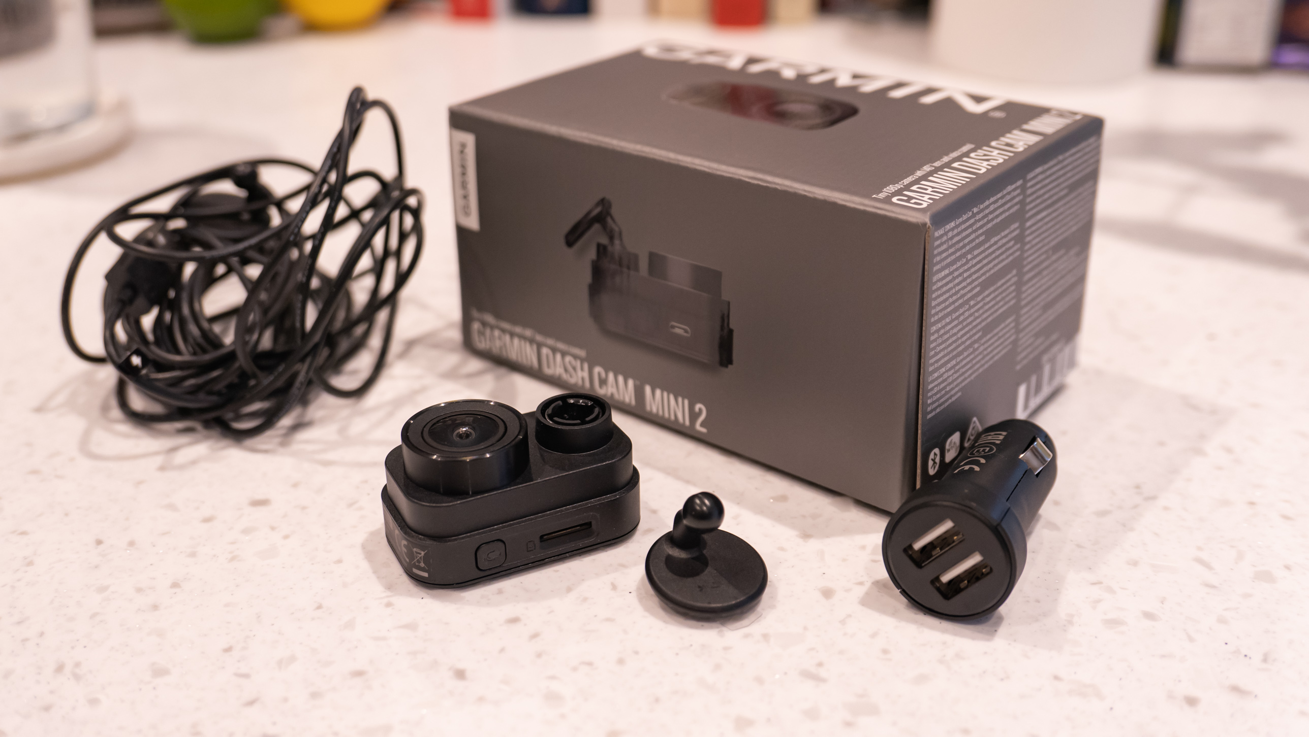 The Garmin Dash Cam Mini 2 next to its box on a table