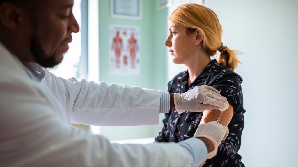 young woman at the doctor&#039;s office receiving a flu shot