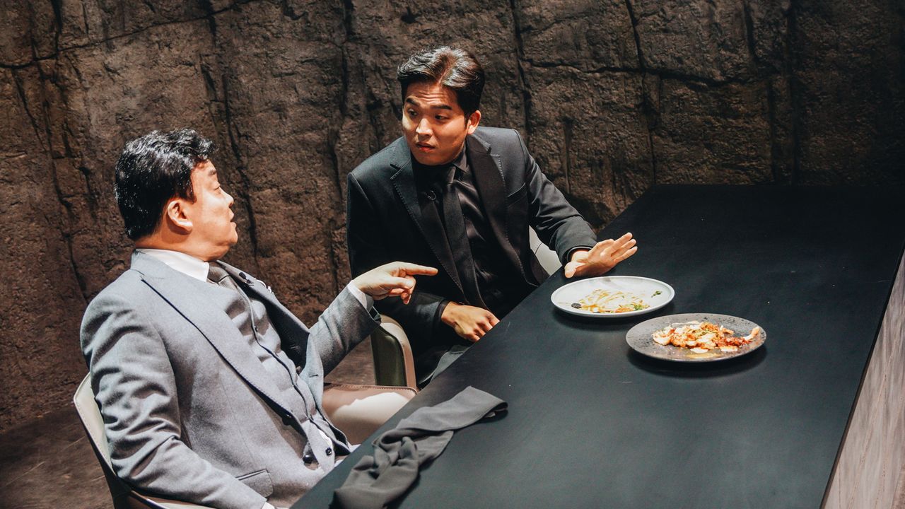 Judges Paik Jong-won and Anh Sung-jae discuss two dishes in a cave-like chamber, in &#039;Culinary Class Wars.&#039;