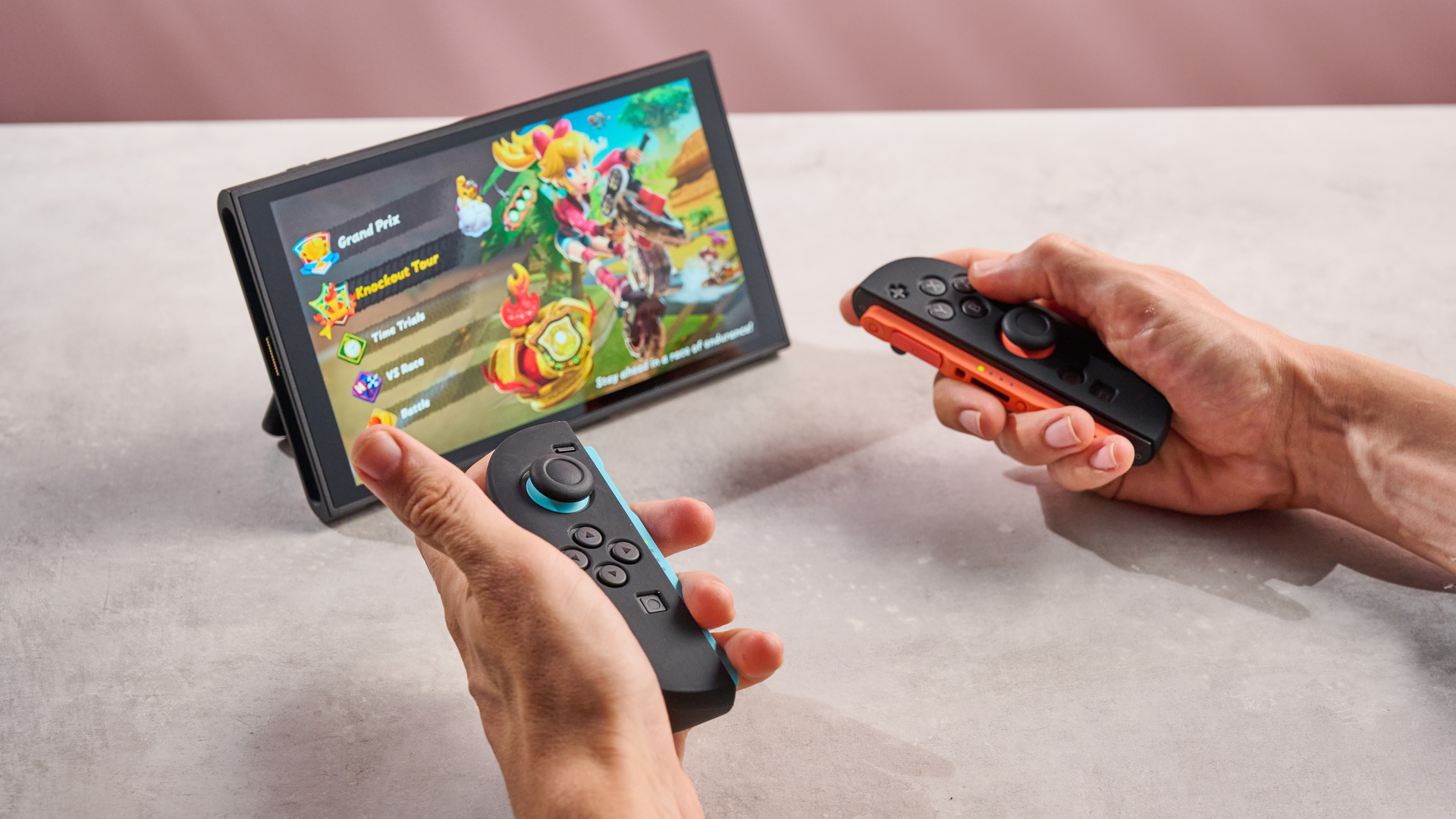 A man holds the Joy-Con 2, showing off the Snakebyte silicone grips that have been applied to them.