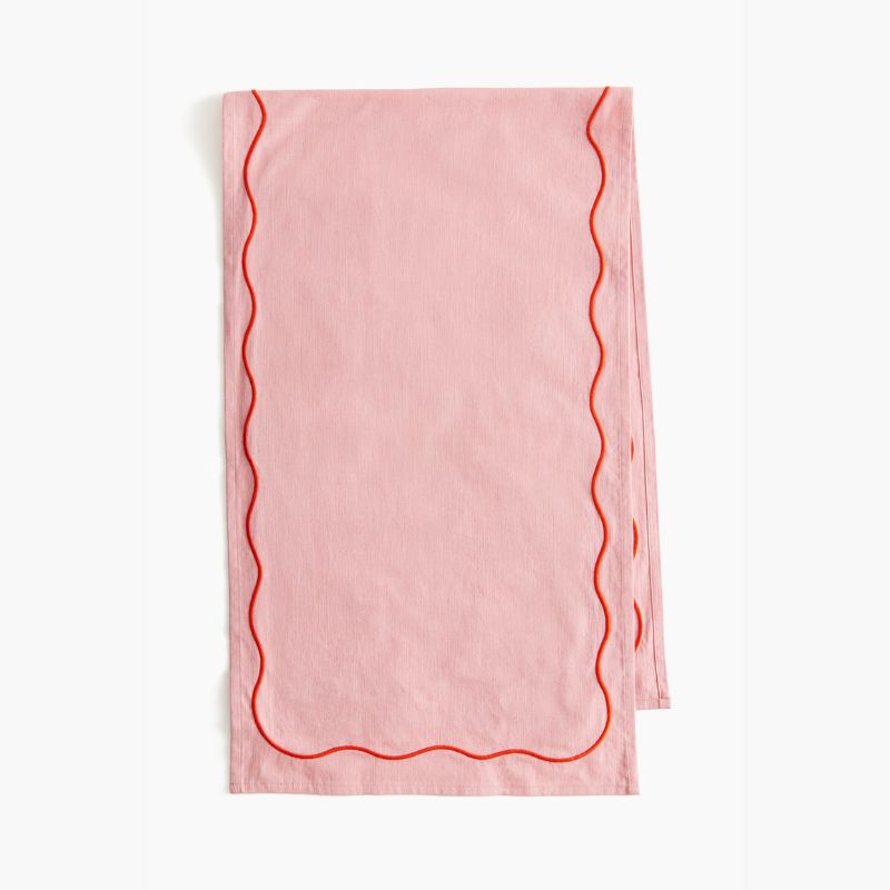 pink table runner with red wavy embroidered detail