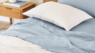 The Buffy Breeze Comforter laid on top of light blue bed sheets