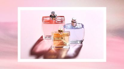 Three colorful glass bottles of perfume in the sun/ against a pink background and in a pastel pink, white and grey sunset scene