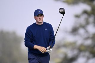 Davis Thompson lines up a tee shot with a driver