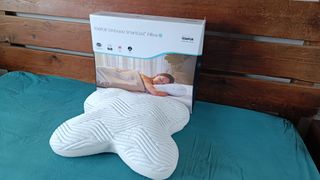 The Tempur Ombracio Smartcool Pillow on a bed with teal sheets, being tested