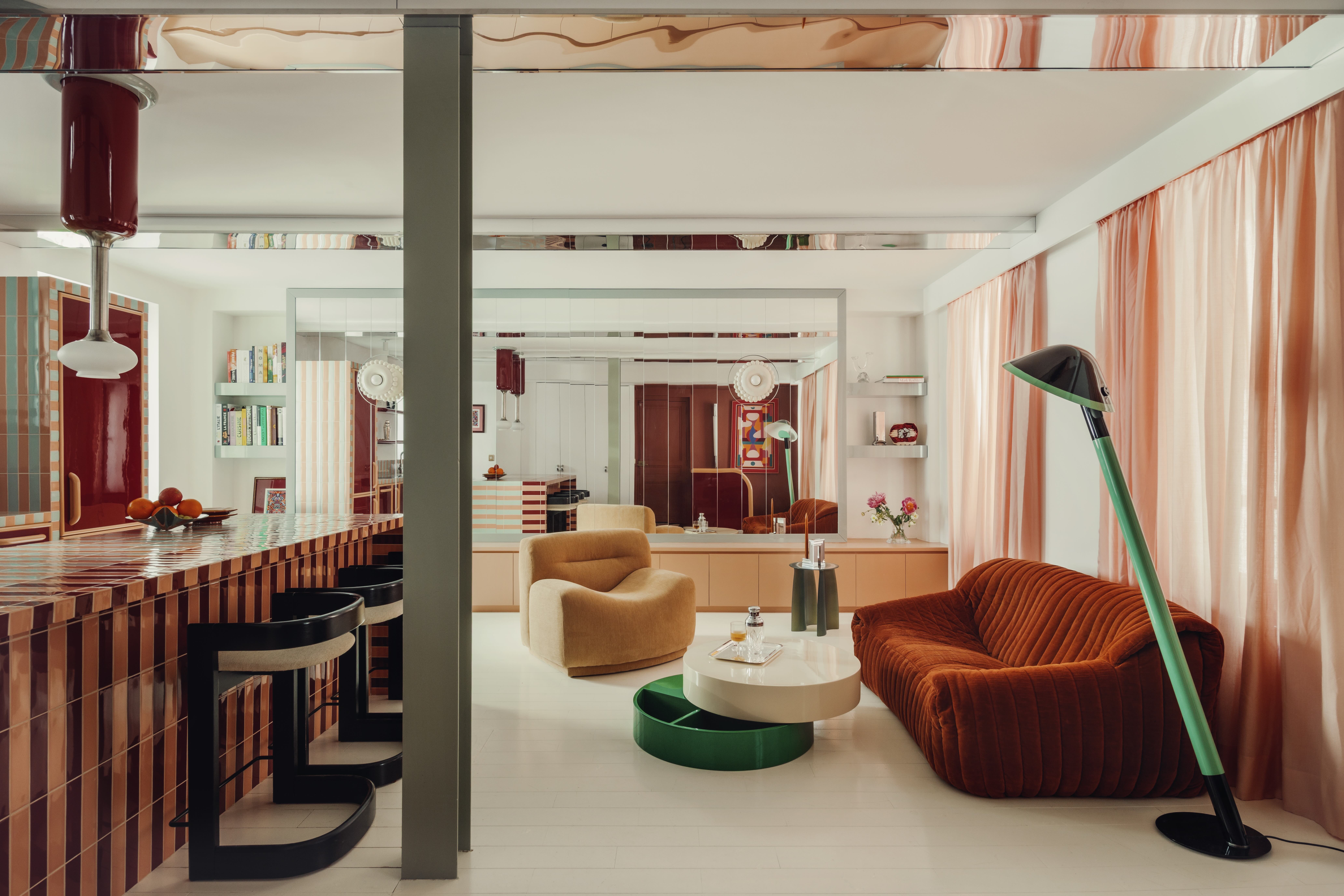 A contemporary living room in a warm neutral palette with a bold green coffee table and floor lamp