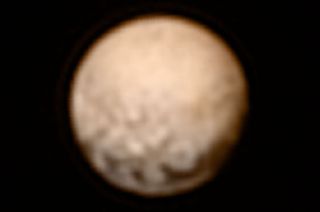 Colorized photo of Pluto as taken by the New Horizons spacecraft on July 3, 2015 at a distance of 8.3 million miles from the dwarf planet.
