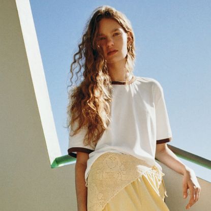 A model wearing a white baseball T-shirt with brown trim and yellow shorts from Loeffler Randall's Long Weekend Collection.