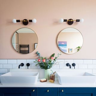 peach and blue bathroom with vanity unit and mirrors