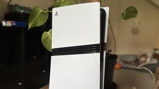 Top section of a PS5 Pro console in front of a houseplant