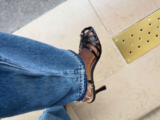 French fashion influencer Sylvie Mus wears Madewell's The Milano Heeled Sandal with relaxed blue denim jeans.