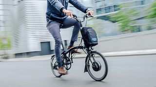 A man riding the Brompton Electric C Line Explore ebike in the street