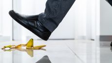 A man is about to step on a banana peel.