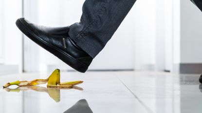 A man is about to step on a banana peel.