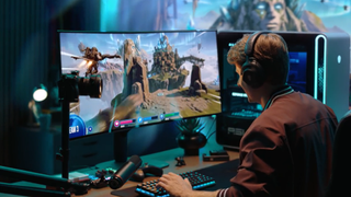 Gamer playing an action game on the Alienware 39 5K OLED gaming monitor (AW3926QW) featuring a 21:9 ultrawide curved screen, next to an Alienware Aurora PC tower.