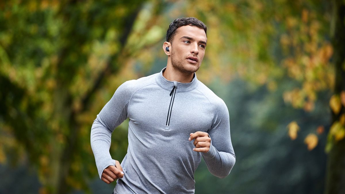 a man running while wearing the jabra elite 4 active true wireless earbuds