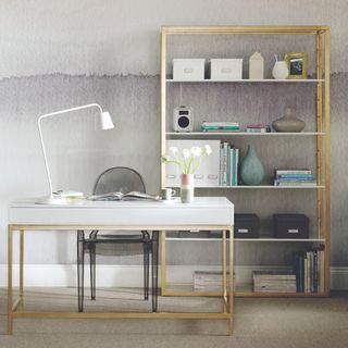 A home office with a gradient-style wallpaper covering the wall behind the desk and a bookcase matching the desk