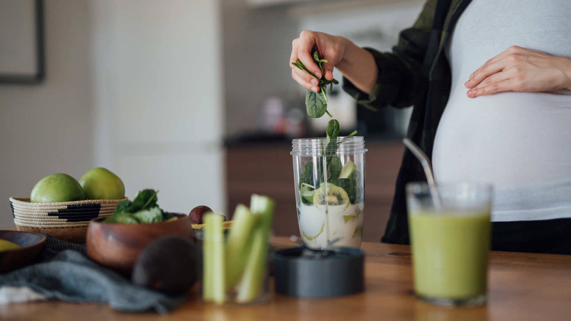 woman making a green smoothie for breakfast