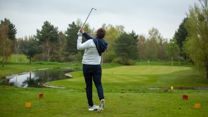 Golfer hits a shot into a downhill par 3