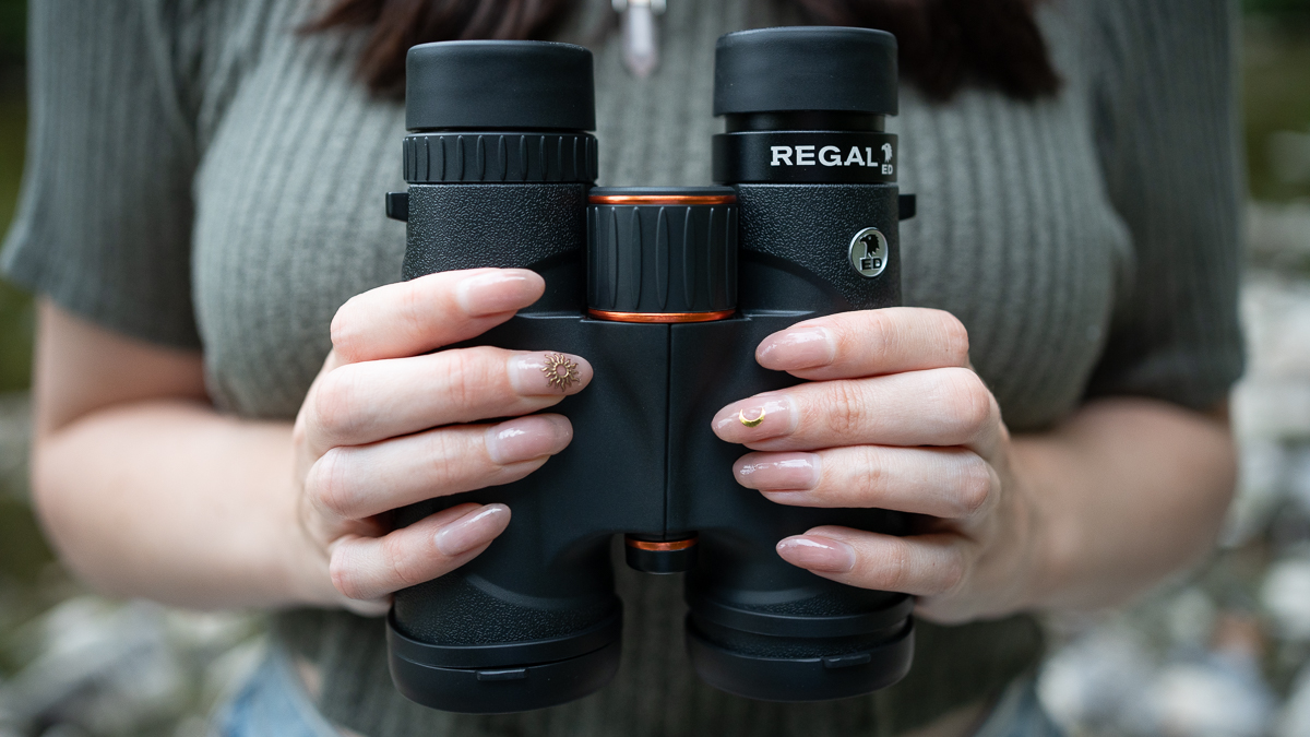 woman using the Celestron Regal ED 10x42 by a river