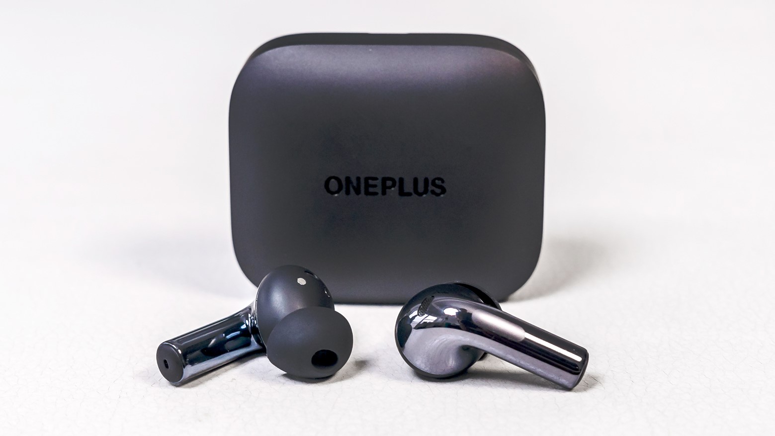 OnePlus Buds 3 earbuds loose in front of case.