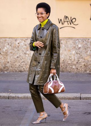 Tamu McPherson, wearing an acid green turtleneck top, green leather jacket with matching pants, brown Prada bag and silver heels, is seen outside Max Mara show, during Milan Fashion Week Fall/Winter 2020-2021 on February 20, 2020