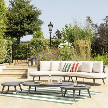 Habitat Santorini 6 Seater Rattan Effect Garden Sofa Set on a patio