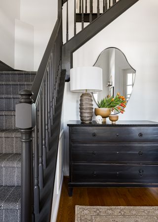 An entryway with a black chest of drawers