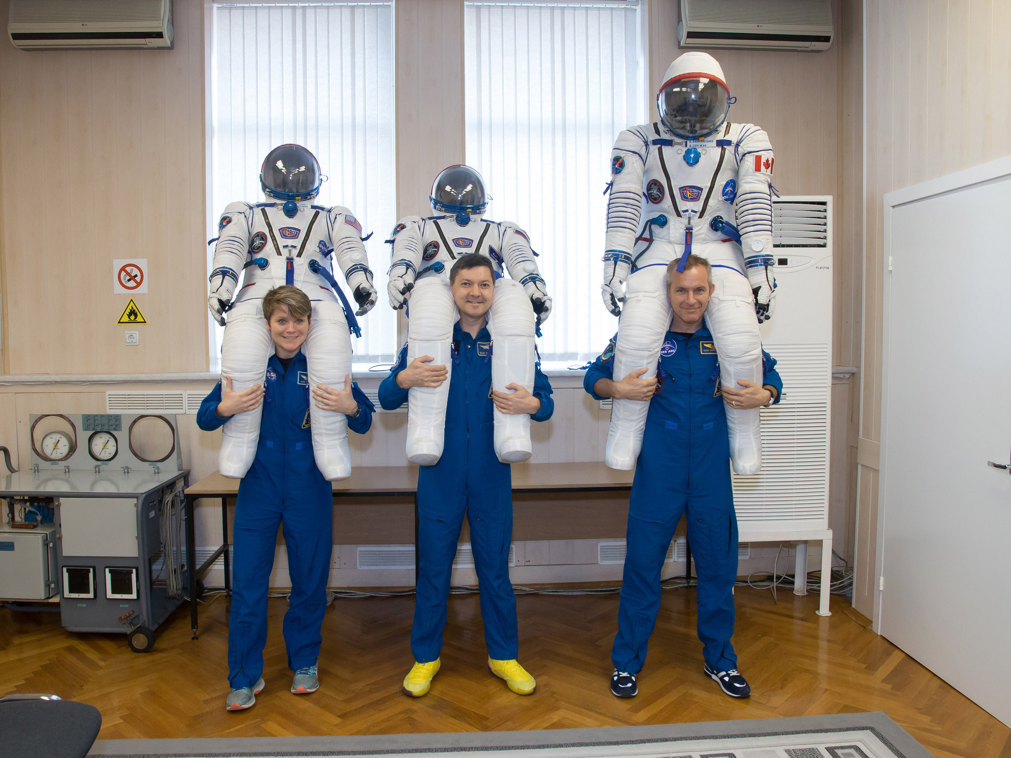 In this image, snapped Nov. 20, NASA astronaut Anne McClain, Russian cosmonaut Oleg Kononenko and Canadian astronaut David Saint-Jacques pose with the suits they will wear during their launch to the International Space Station on Dec. 3.