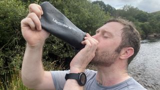 Man drinking from Lifestraw water bottle