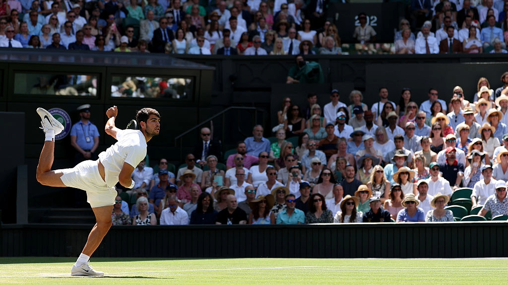 Carlos Alcaraz serves during his Wimbledon semifinal with Taylor Fritz