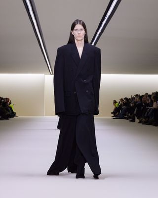 Woman in black suit in glasses on Balenciaga runway