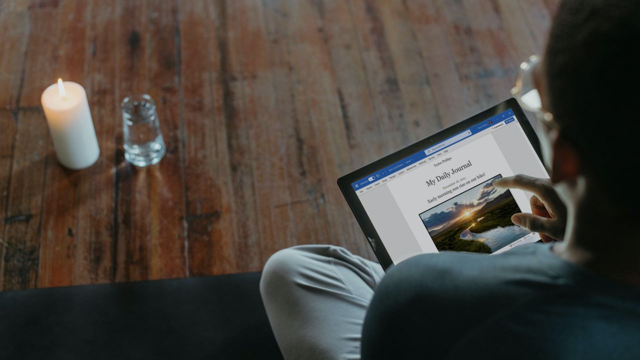 Man sitting crossed legged on floor looking at tablet