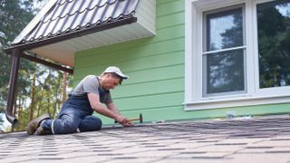 Man fixing roof tiles
