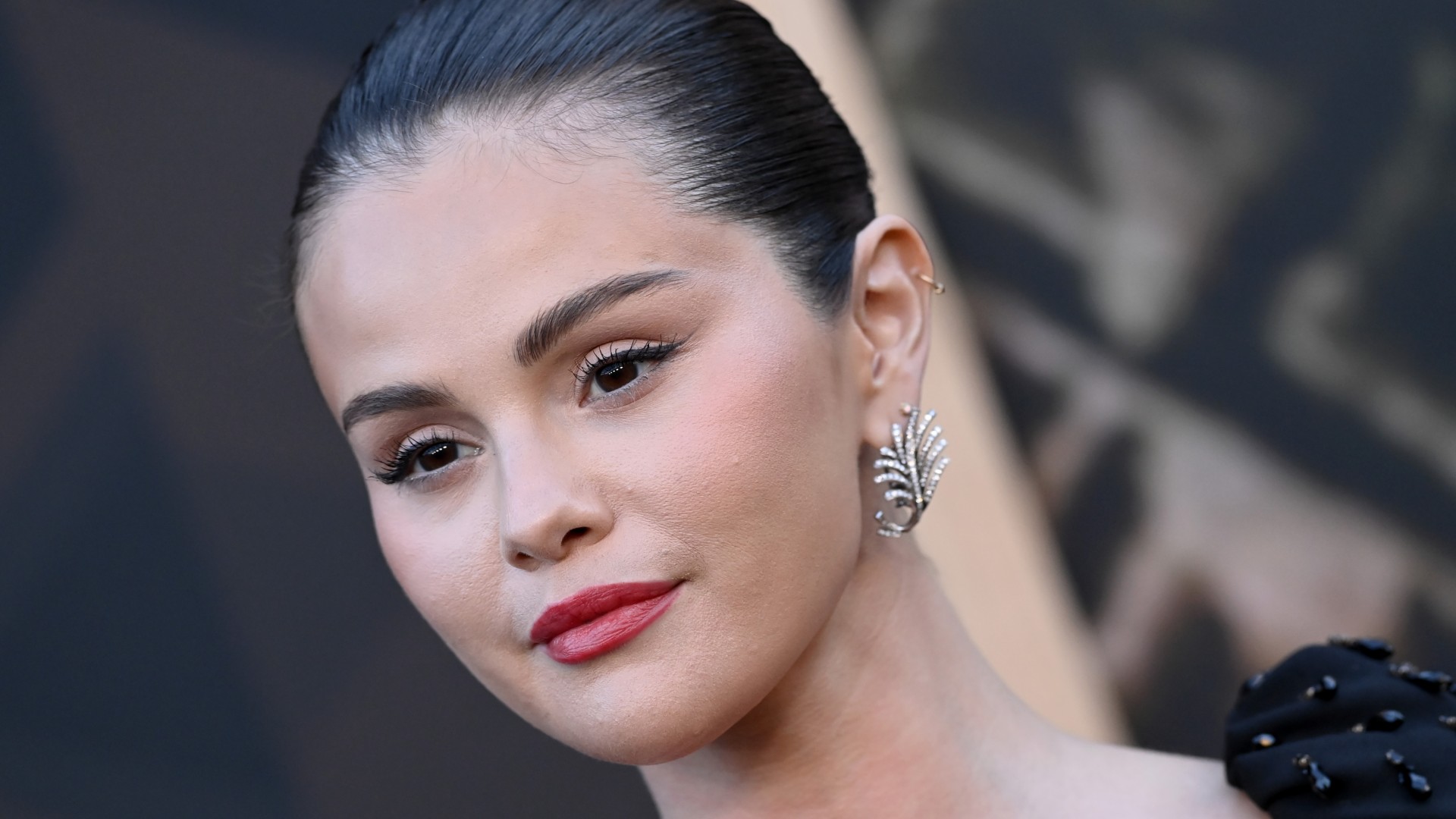 selena gomez attends a film premiere in los angeles in red lipstick and silver earrings