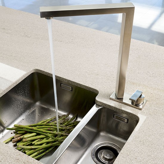 spacious kitchen with central peninsula and stainless steel sink