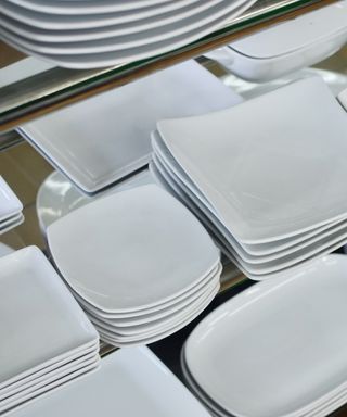 An image of stacked thin white plates in different sizes and shapes