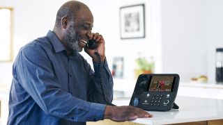 A man grins as Doom plays on his CaptionCall phone