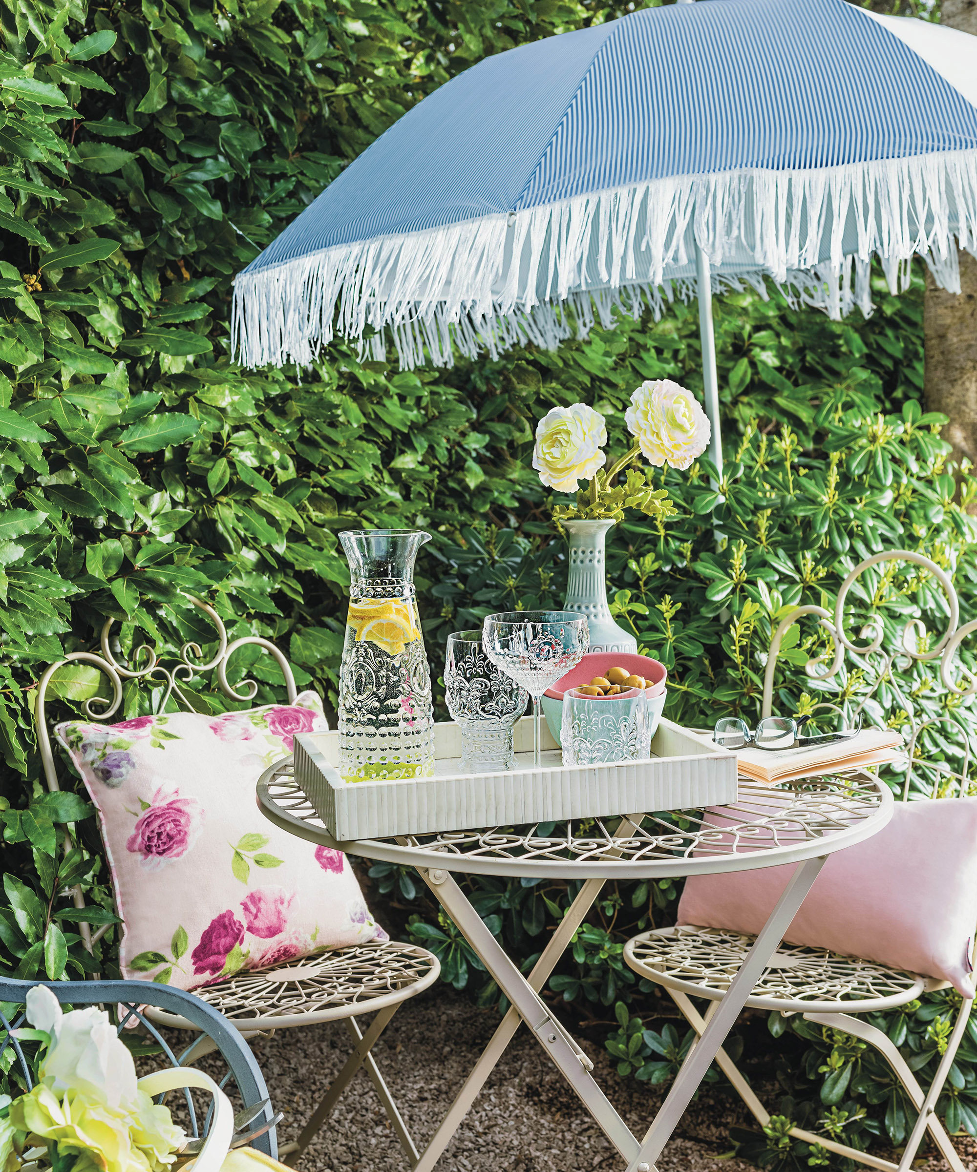 A light blue parasol over a garden seating area