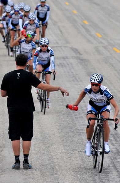 Head mechanic Dave Drumm hands out bottles during a training camp drill