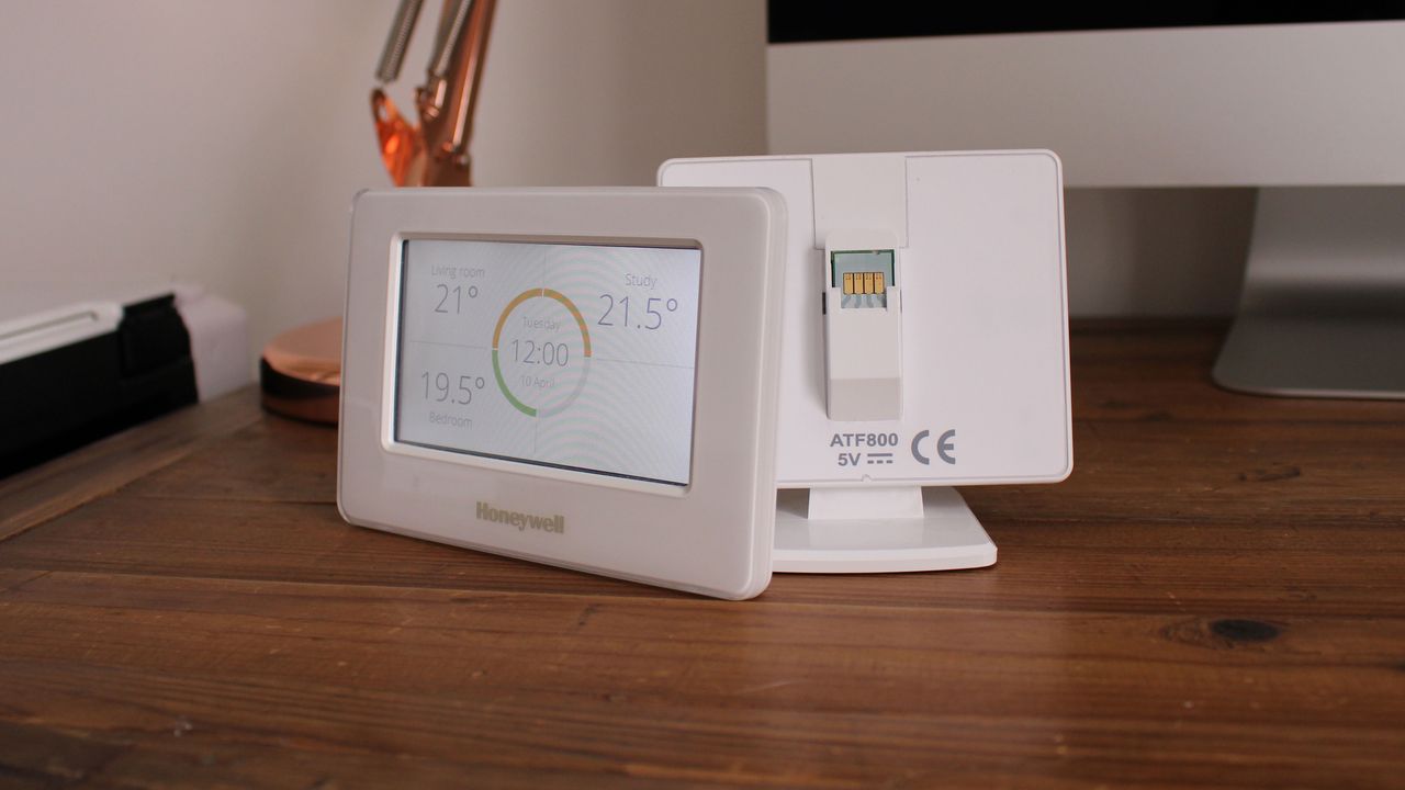 Honeywell Evohome smart thermostat terminal detached from its dock, which serves as a charging platform. The terminal can be removed and carried around your home