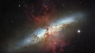 Hubble Telescope observations of the glorious galaxy M82, bursting with white starlight and red gas clouds. Stars are forming 10 times faster here than in our Milky Way, according to NASA.