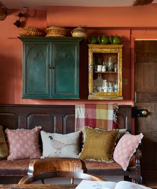 old wooden settle and wall cupboards in a country kitchen