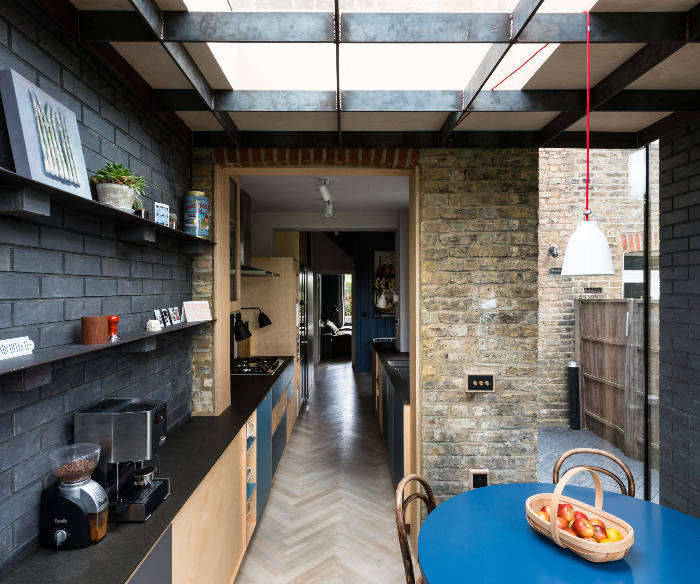 inside small house extension with blue brick walls and kitchen inside