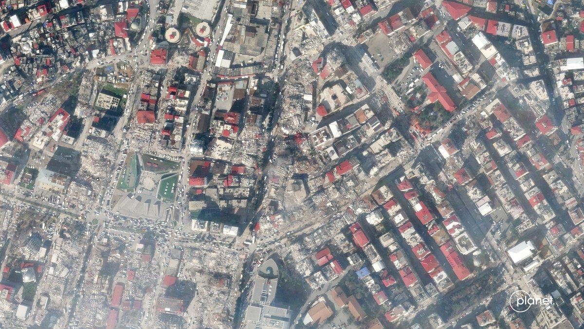 damaged buildings and rubble seen at the street level from above