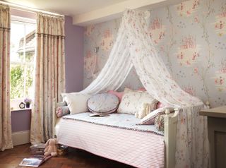 girls bedroom with day bed, fabric canopy, fairytale wallpaper, print drapes, mixture of patterned bed pillows, lilac walls