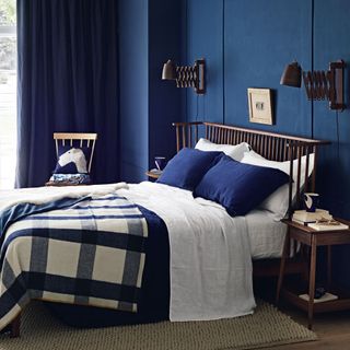 blue wall bedroom with brown wooden bed blue curtains on window and cream colour flooring