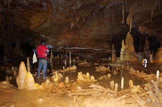 Scientists take measurements of the stalagmite structures in Bruniquel Cave.