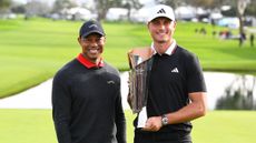 Tiger Woods and Ludvig Aberg pose with the Genesis Invitational trophy after the Swede's win in 2025